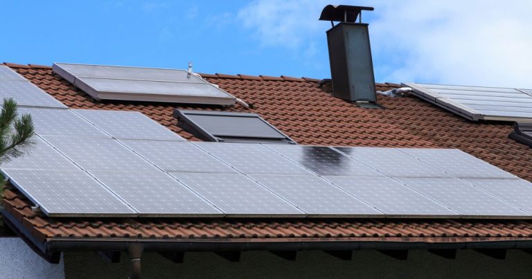 Bild einer Photovoltaikanlage auf einem Hausdach. Die Sonne scheint.